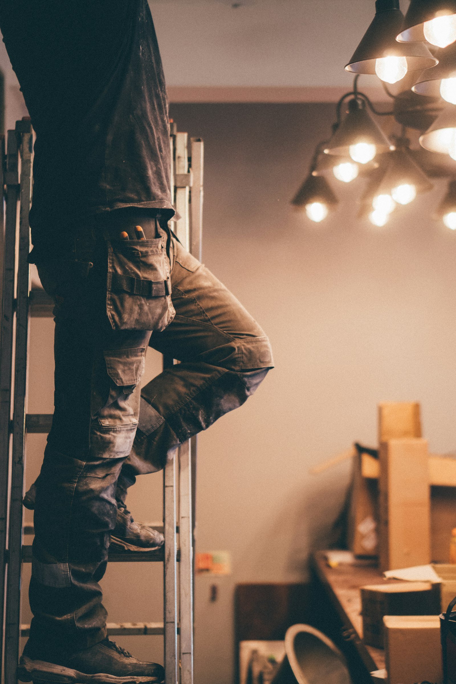 Electrician on ladder fitting ceiling light in Kingswells