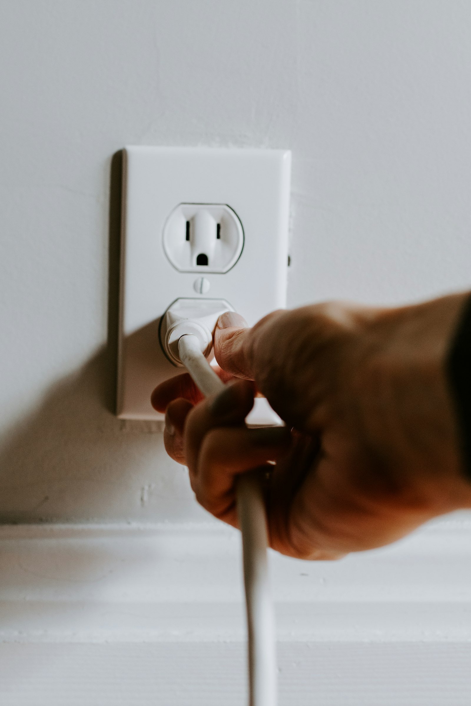 Hand plugging into wall socket home in Maryculter