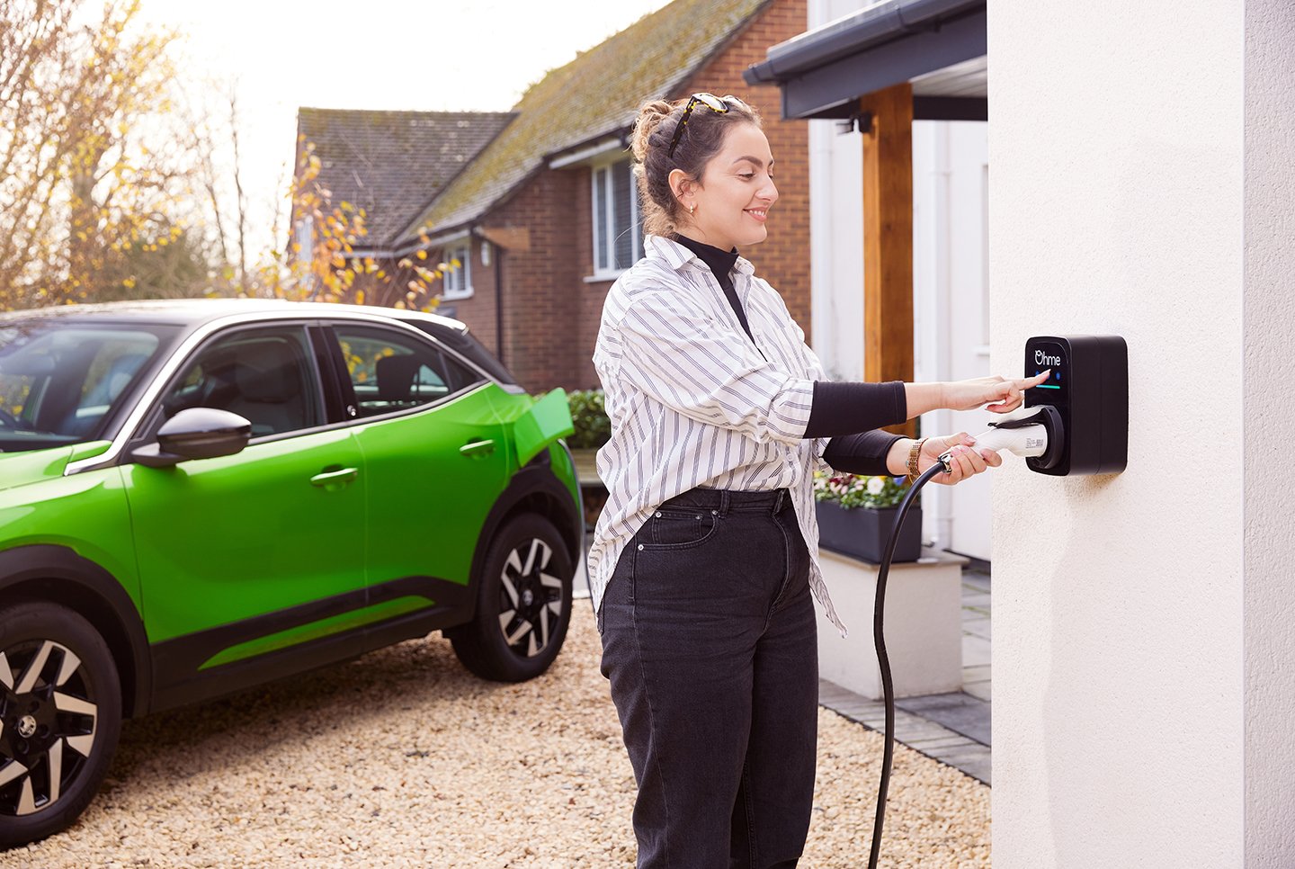 Driver charging an electric car with an Ohme ePod at a Danestone home