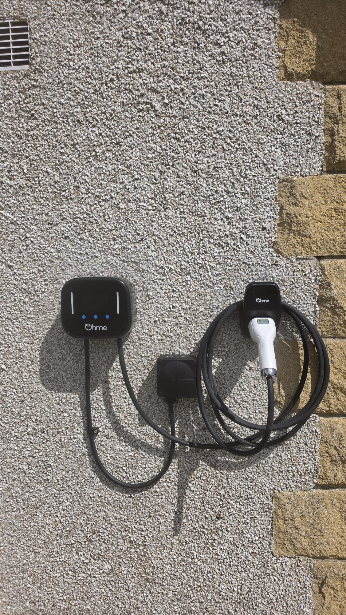 Ohme Home Pro EV charger discreetly installed on a granite West End frontage