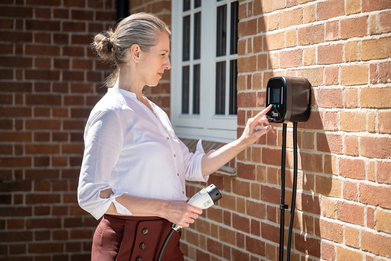 Homeowner using the app on an Ohme Home Pro EV charger in Cove Bay