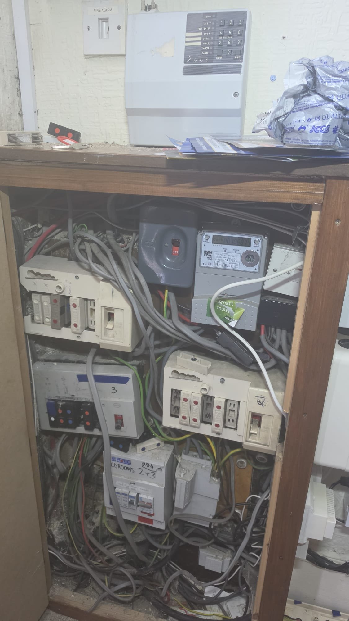 Old commercial distribution board in Aberdeen before rewire. Tangled wiring, dated RCDs and fire alarm panel, in need of full refurbishment