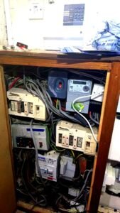 Aberdeen HMO rewire before photo showing old deteriorating wiring across multiple ageing consumer boards