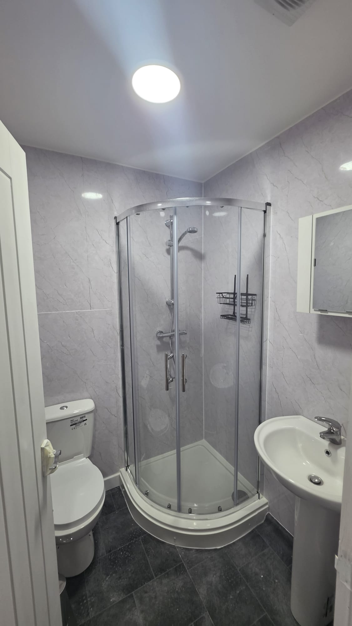 En suite shower room in a Peterhead accommodation conversion with a sealed ceiling light and a recessed downlight