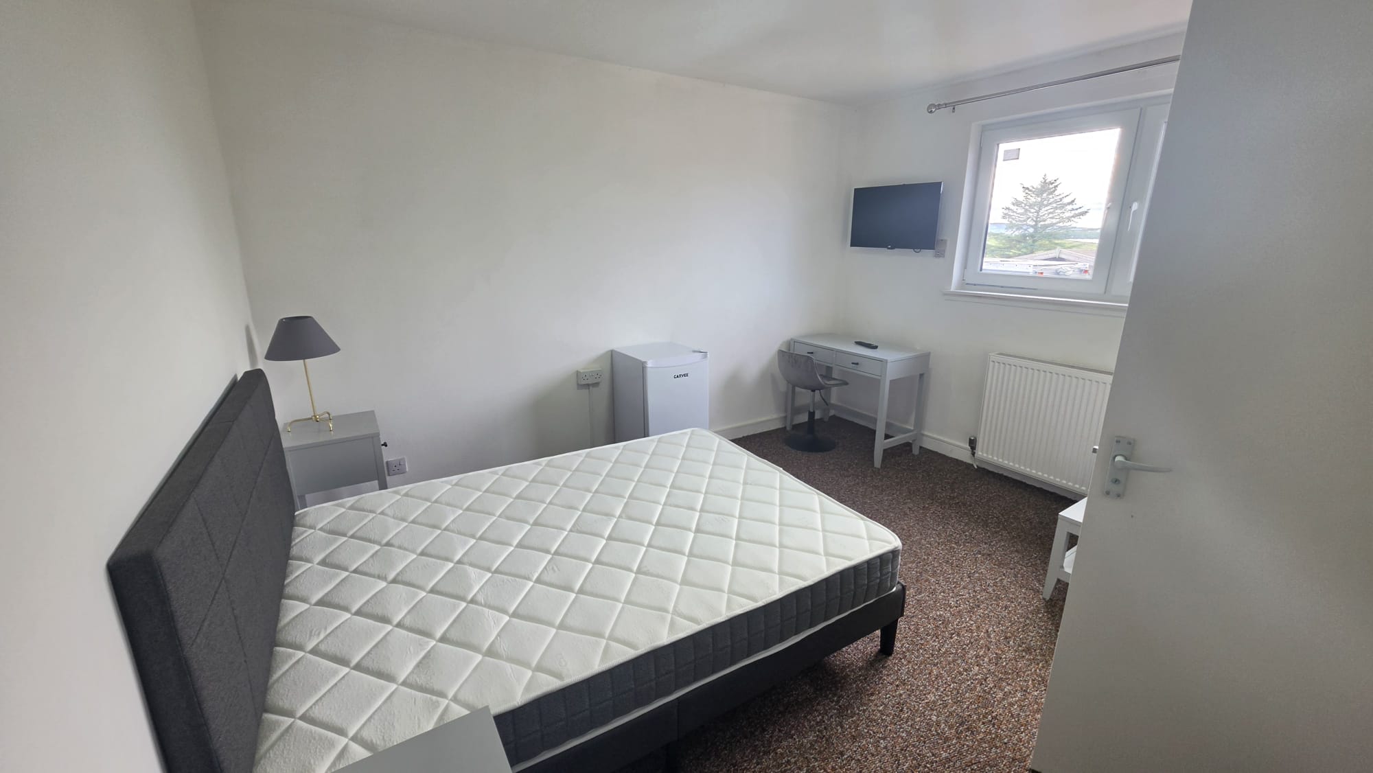 Letting room in a Peterhead accommodation conversion with ceiling light, desk, wall mounted television and sockets