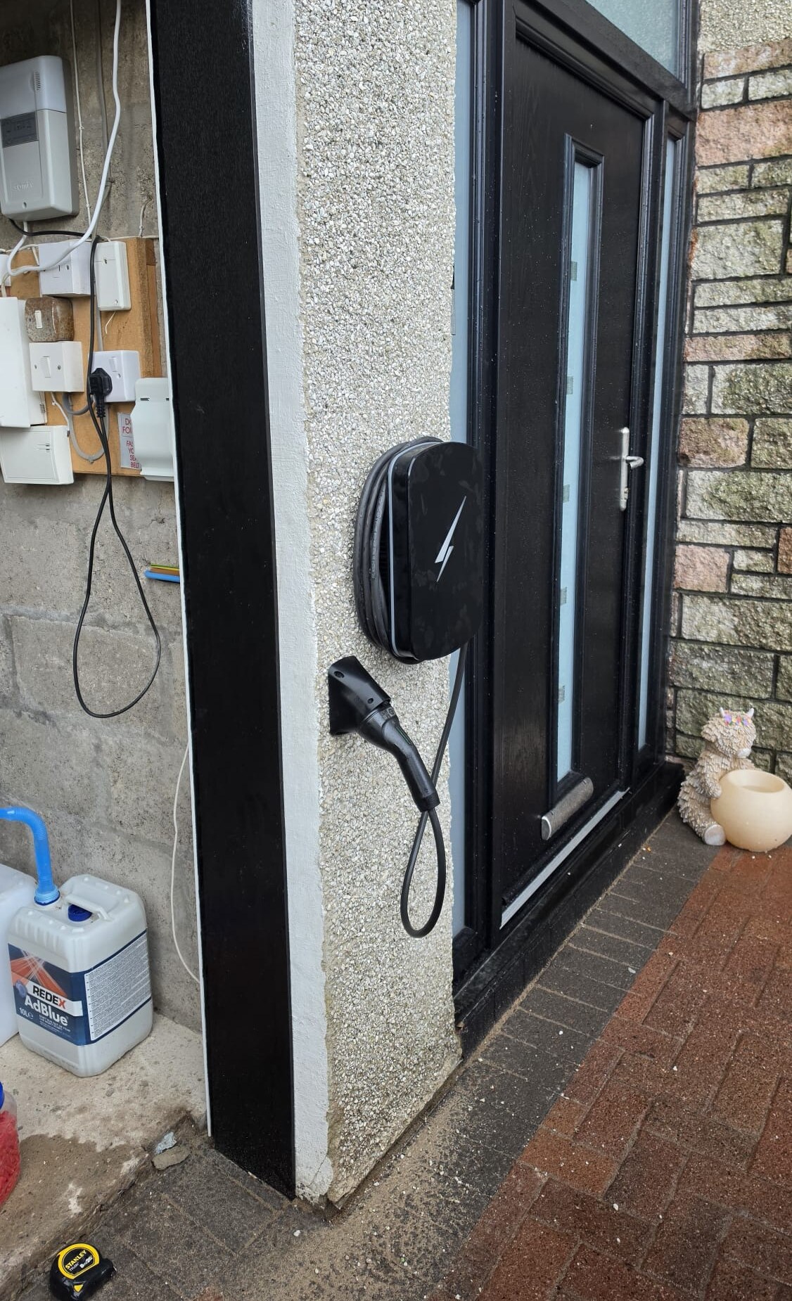 Hypervolt EV charger fitted by our team on a pebbledash pillar beside a front door in Balmedie, cable stowed on the unit