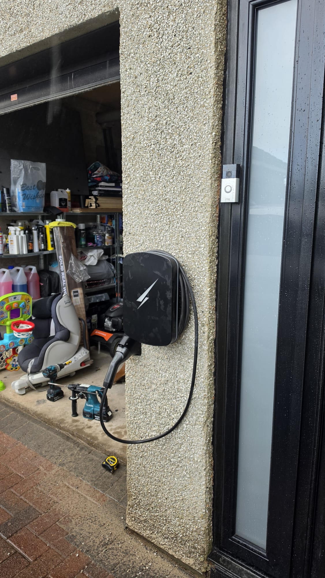 Hypervolt EV charger on the pillar between a garage opening and the front door, cable looped neatly to its holster, fitted by our team in Balmedie