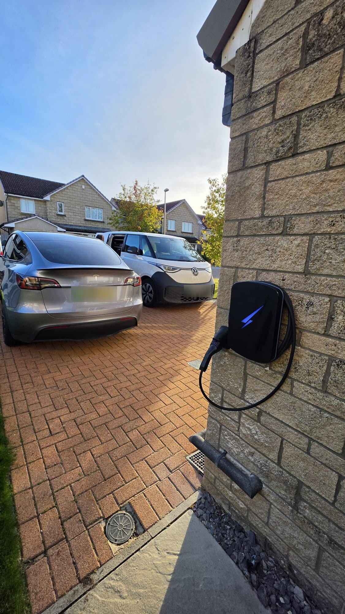Hypervolt EV charger fitted to a stone effect garage wall beside a block paved driveway in Westhill