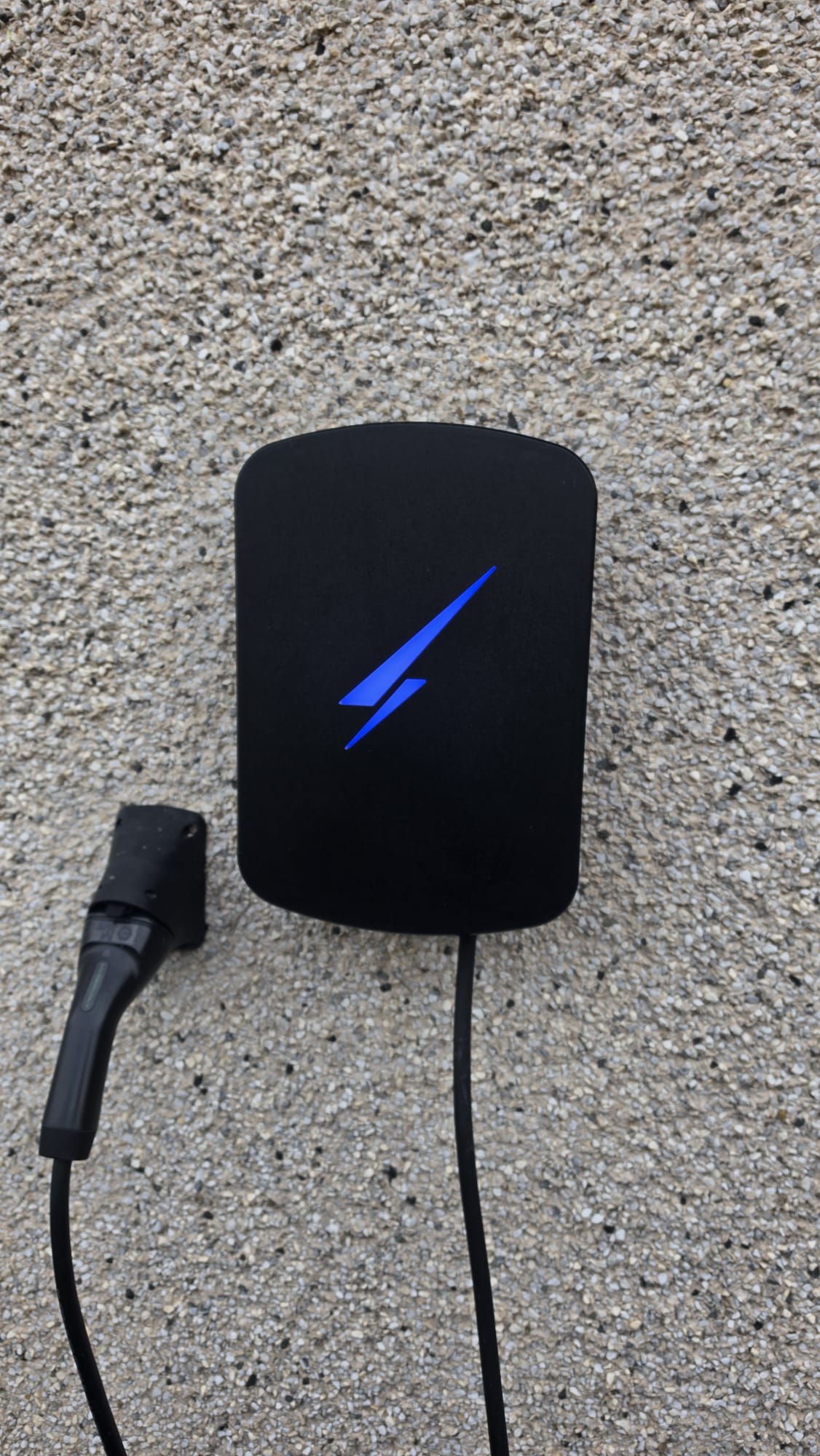 Hypervolt EV charger with its blue light on, fitted to a pebbledash wall in Peterhead