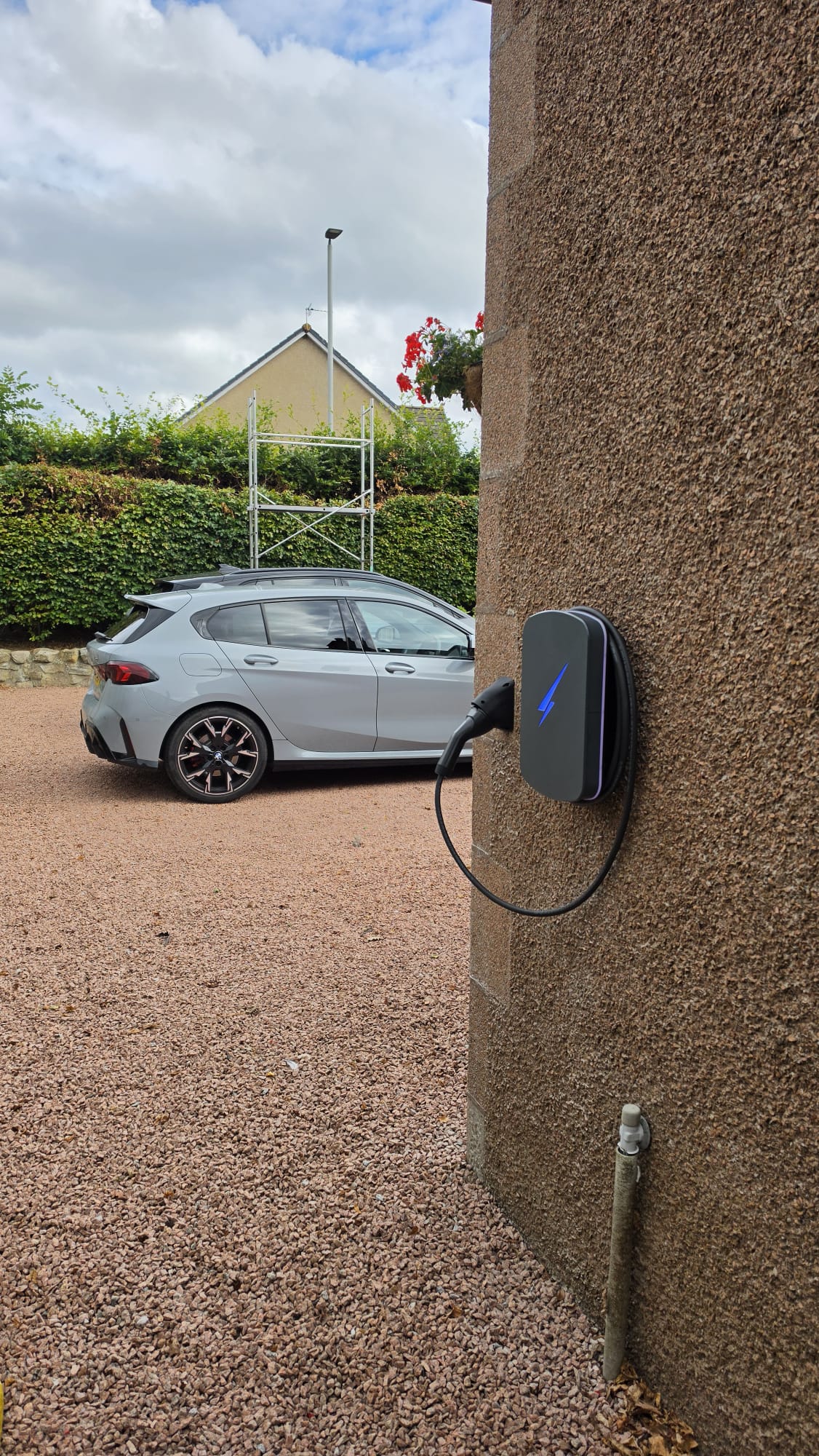 Hypervolt EV charger on a rendered gable wall in Kintore with its charging cable looped and the connector stowed in the holster