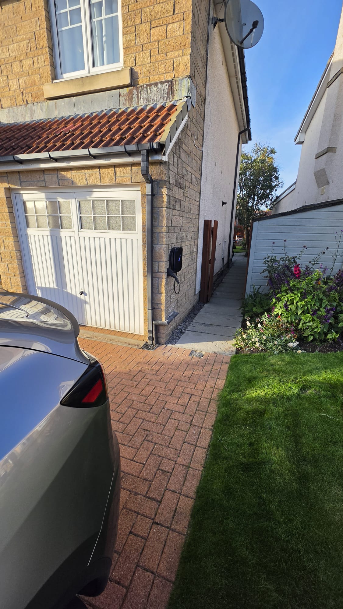 Hypervolt EV charger beside a white garage door on a block paved driveway in Westhill