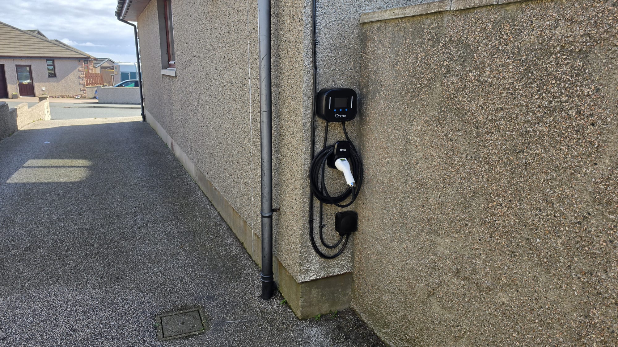 Ohme EV charger on a Peterhead pebbledash wall with the cable run clipped neatly